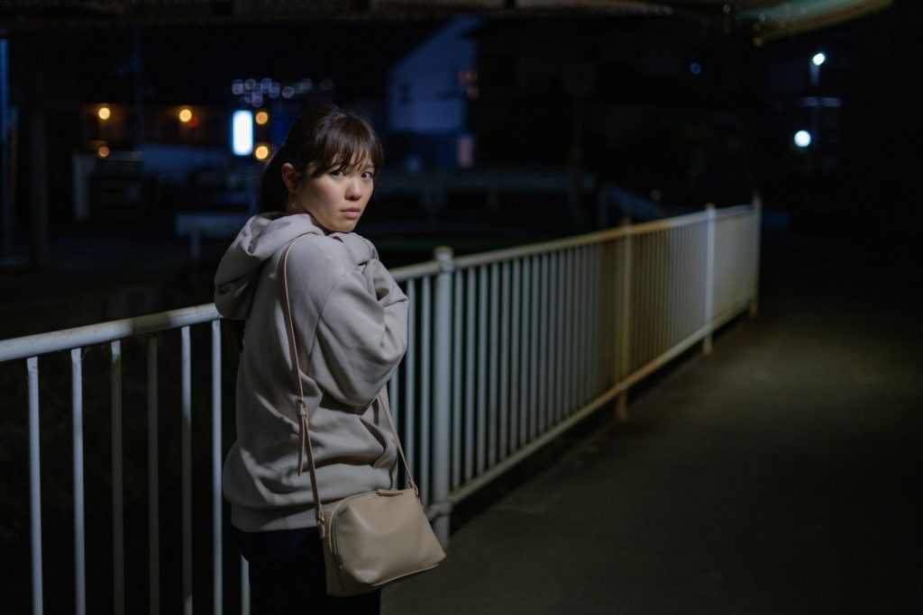 夜道で振り返る女性